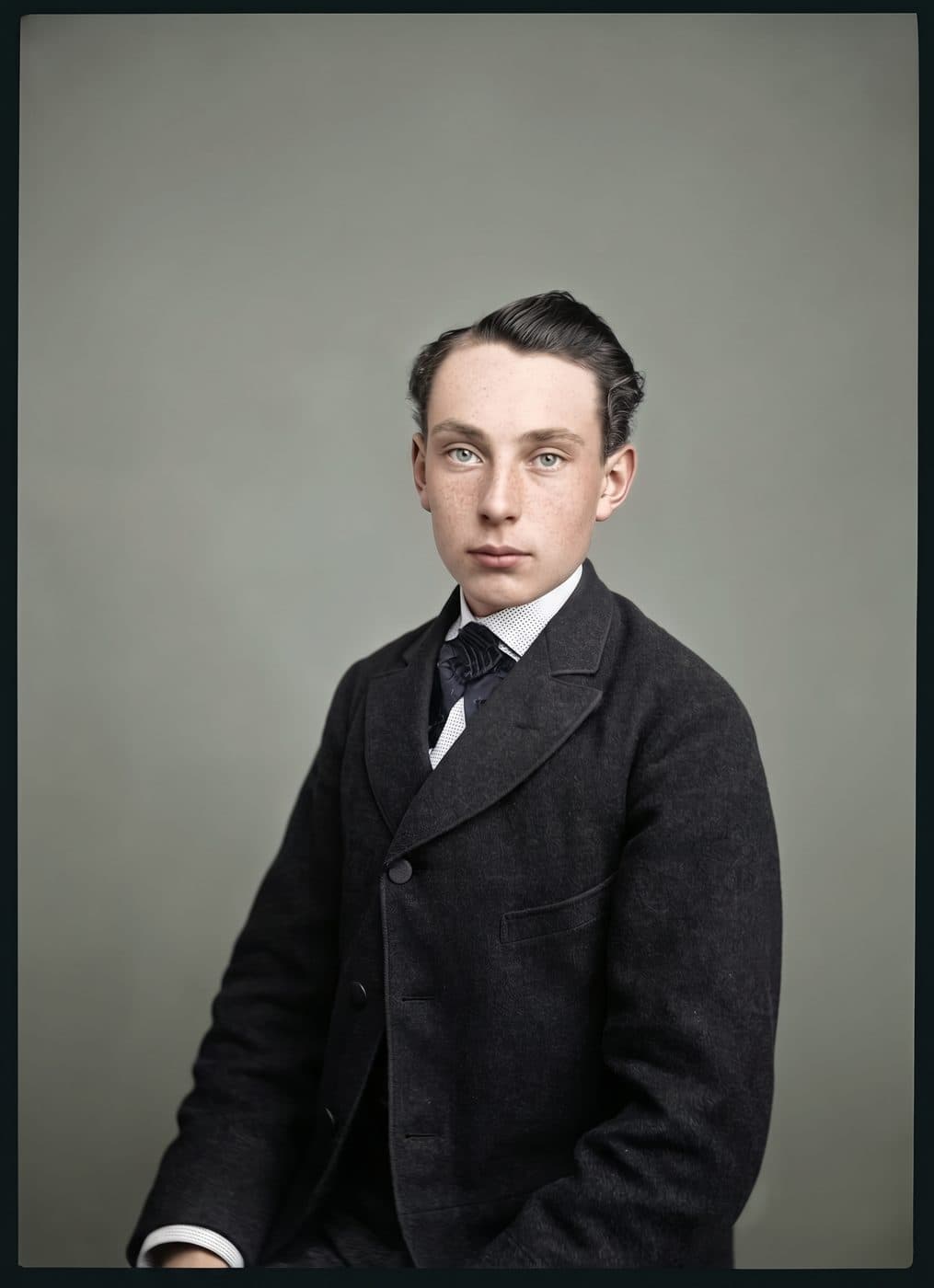 A spotted and stained studio portrait of a young man in a dark suit, restored and colorized
