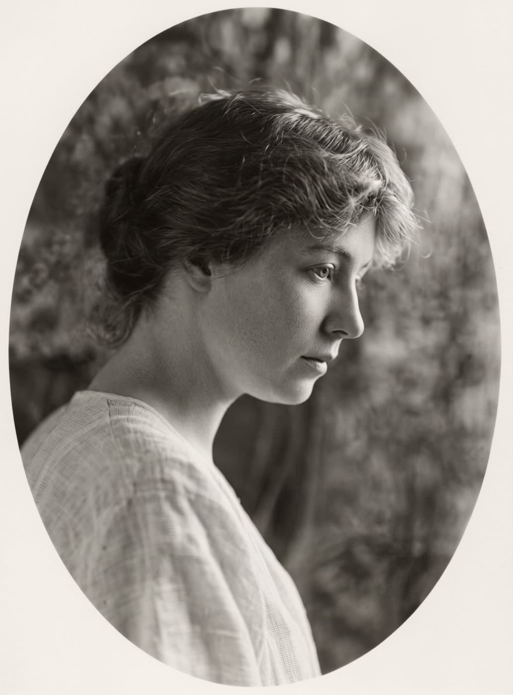 A scratched, grainy 1914 newspaper portrait of a young woman in profile, restored