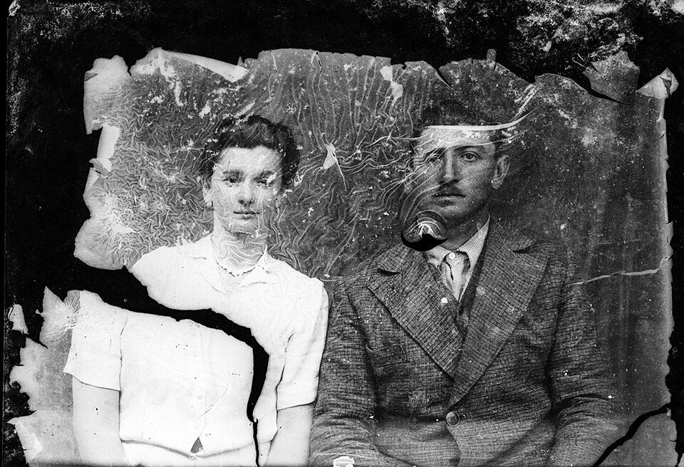 A young couple on a cracked and peeling glass-plate negative, before restoration