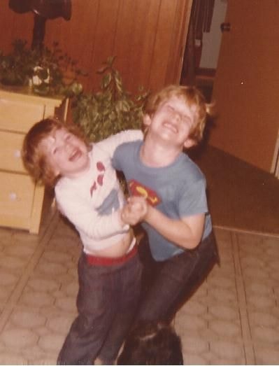 A 1970s snapshot of two laughing boys playing in a living room, before upscaling