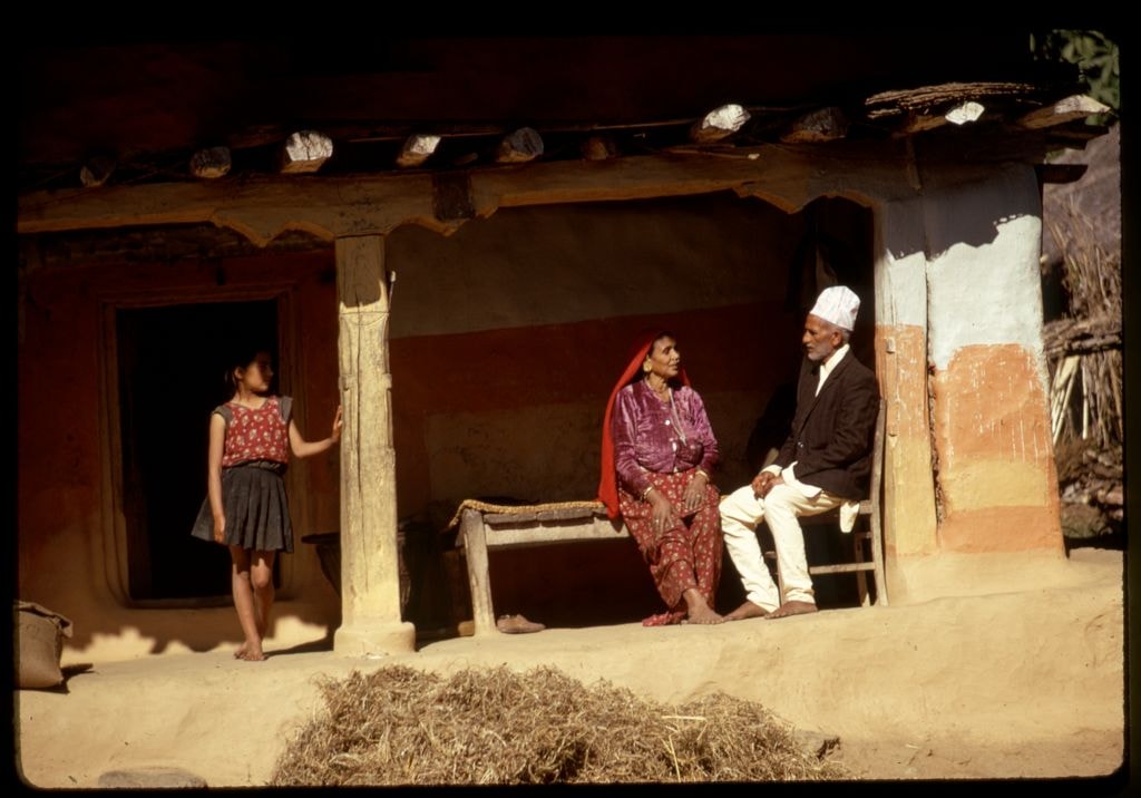 A colour slide of a family outside a clay house in Sikkim, before upscaling